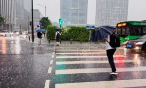 Miền Nam Trung Quốc xuất hiện thời tiết “băng - hỏa” đối lập 1 nguoi dan di chuyen trong tran mua lon o quang chau tinh quang dong mien nam trung quoc ngay 30 3 20